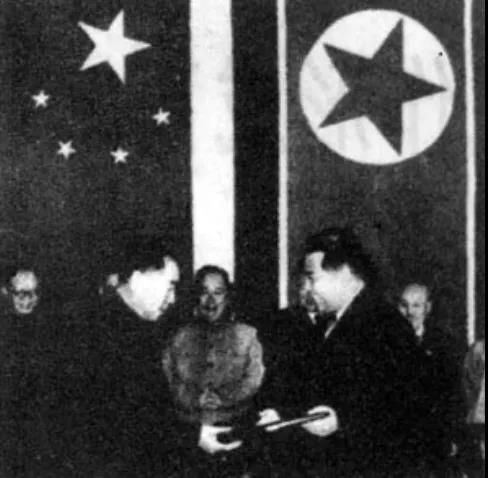 △周恩來(lái)和金日成在簽字后互換議定書(shū)。.jpg
